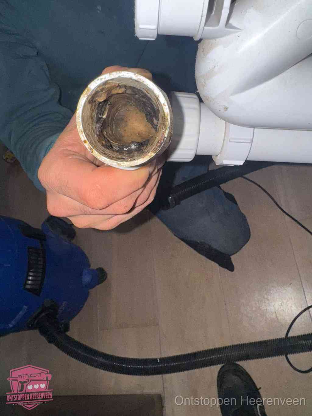Een losgekoppeld afvoerbuisstuk dat van binnen volledig is dichtgeslibd, het gevolg van een verstopping te lang laten zitten in Heerenveen