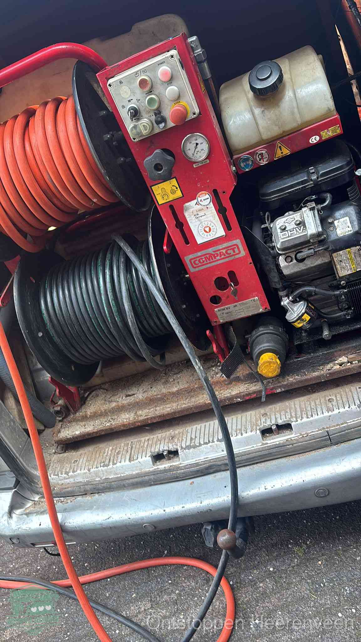 Een rood hogedruk-rioolreinigingstoestel in de laadbak van de bedrijfsbus, apparatuur voor een hardnekkige afvoerverstopping in Heerenveen