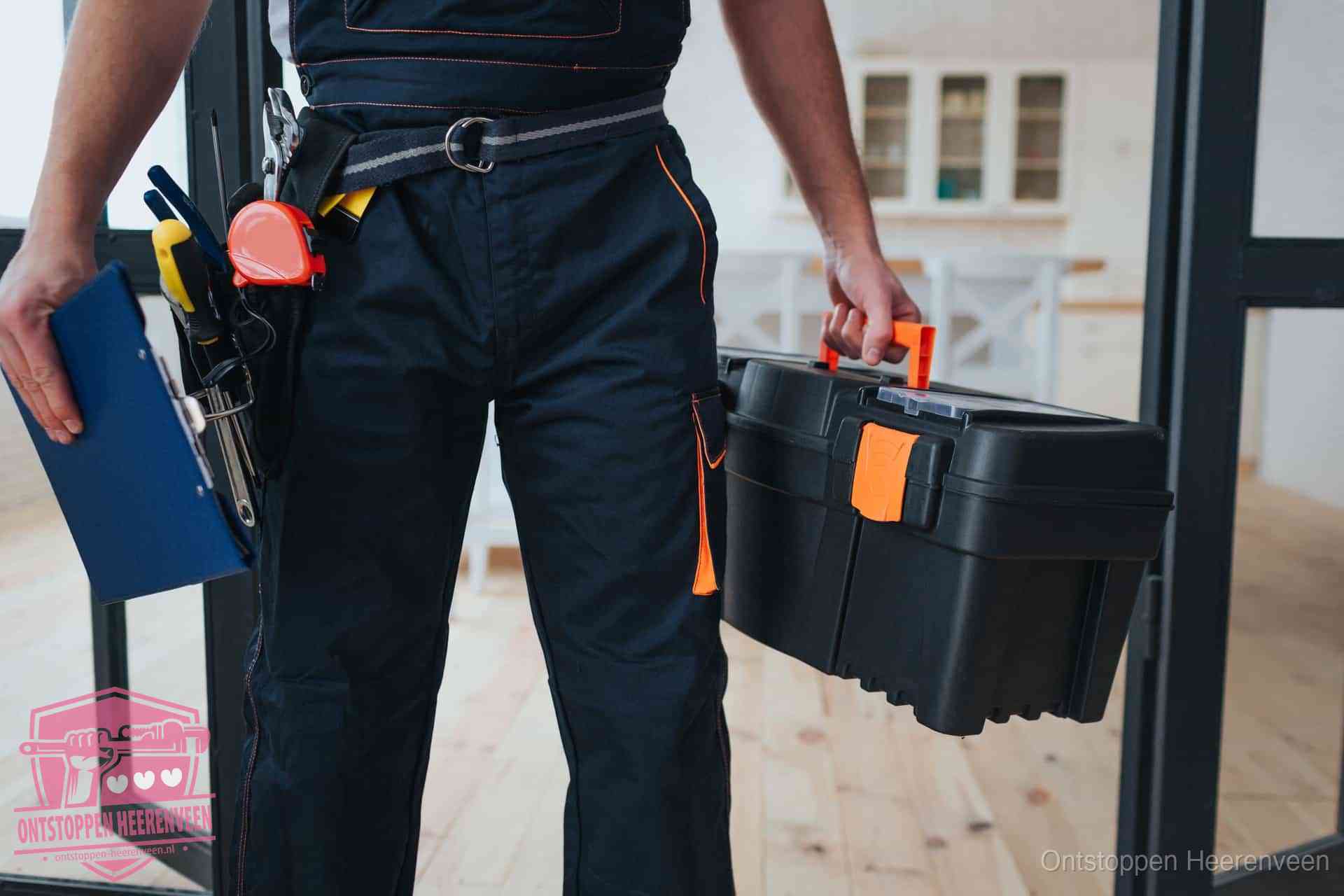 Een monteur met gereedschapsriem en klembord in een keuken, klaar om een transparante prijs voor het gootsteen ontstoppen in Heerenveen te geven