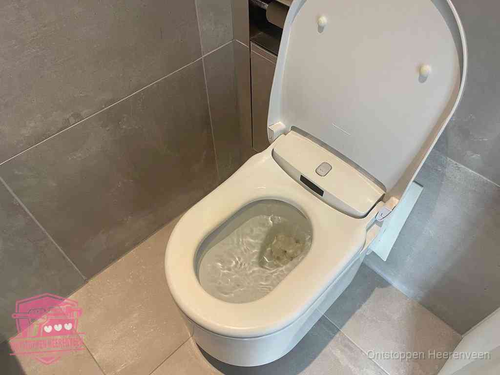 Een toiletpot vol troebel water met drijvend papier en restanten, de meest voorkomende oorzaak van een verstopte wc in Heerenveen