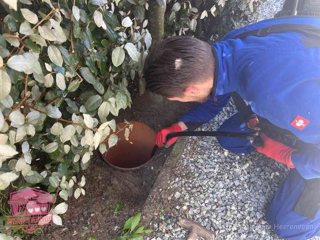 Monteur reinigt een rioolput met een slang, periodieke rioolreiniging in Heerenveen