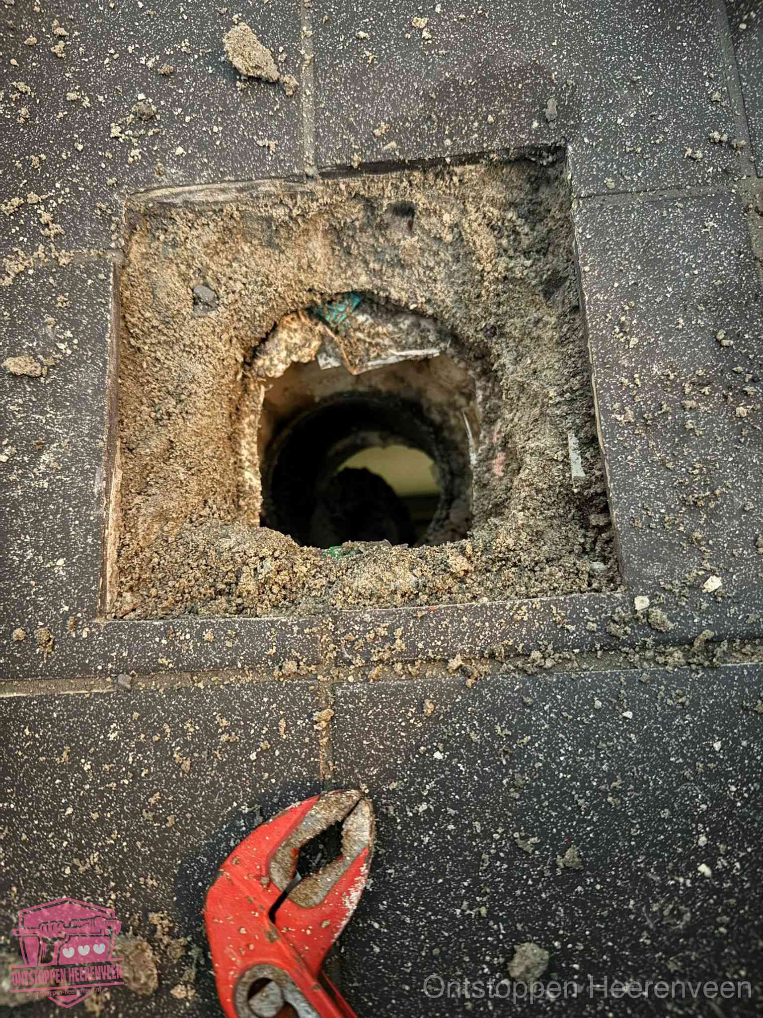 Geopend rioolputje op de erfgrens dat laat zien wie eigenaar is van de riolering in Heerenveen