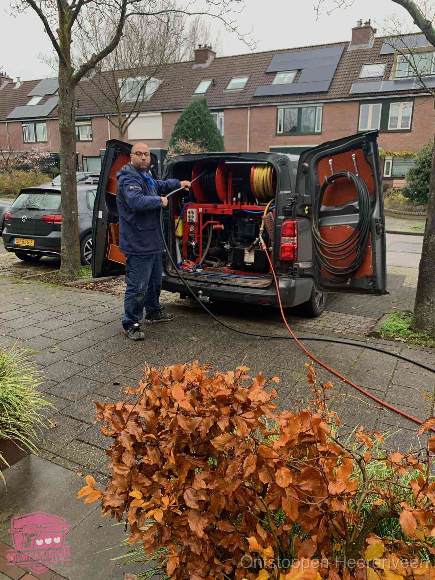 Monteur met rioolreinigingsbus levert rioolservice in de wijk in Heerenveen