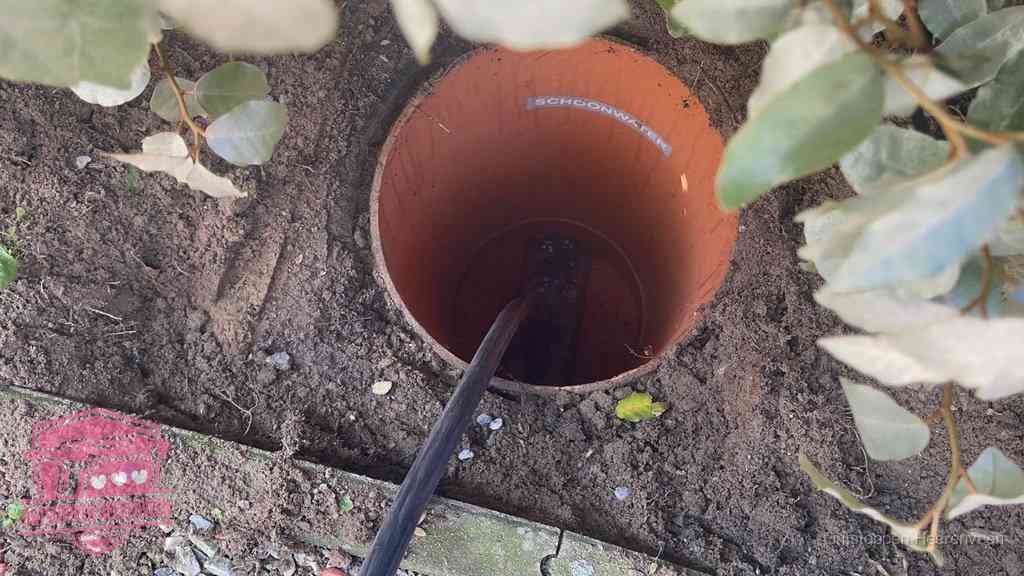 Open inspectieput in de tuin waar een veer rioolvliegjes en stankoverlast aanpakt in Heerenveen
